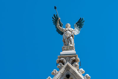 Low angle view of statue against blue sky