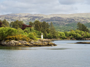 View of caladh lighthouse and beautiful trees in glen caladh harbour, kyles of bute, scotland