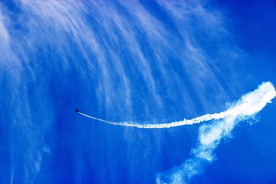 Low angle view of vapor trail against blue sky