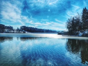 Scenic view of lake against sky during winter