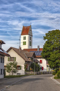 Road amidst buildings against sky