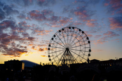 Low angle view of ferris wheel against sky at sunset