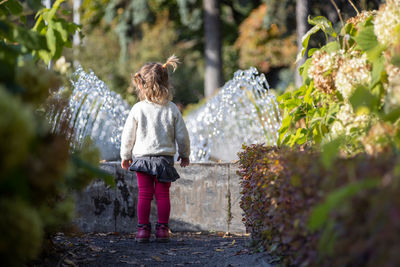 Rear view of woman standing by plants