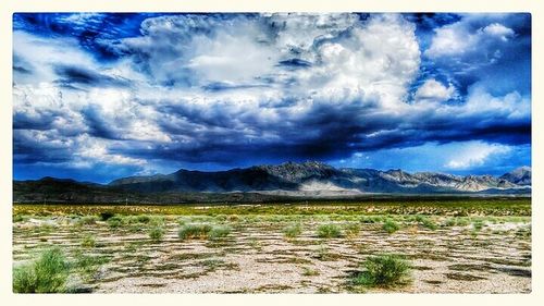 Scenic view of mountains against cloudy sky