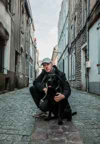 Portrait of man with dog in city