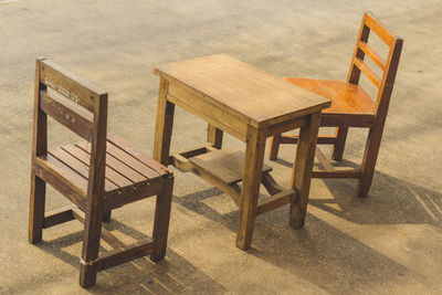 High angle view of empty chairs and table on beach