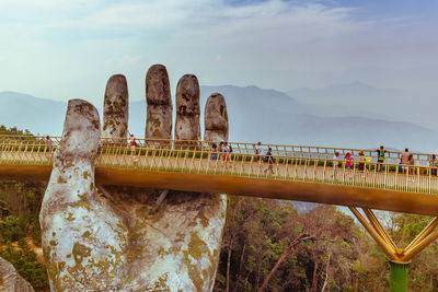 People on bridge against sky