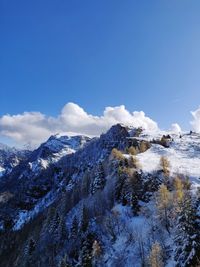 Scenic view of snowcapped mountains against blue sky