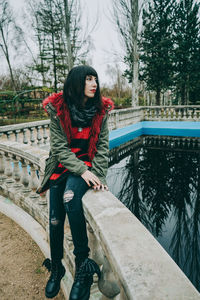 Woman standing by railing against canal