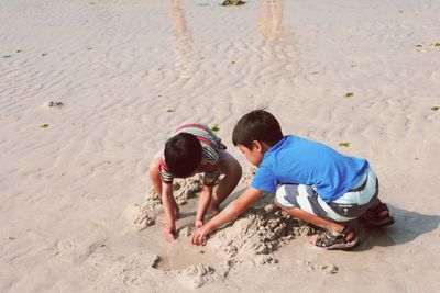 High angle view of friends playing on wet sand at beach