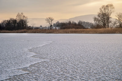 Scenic view of snow covered land against sky