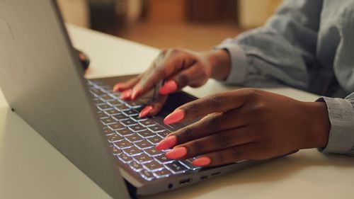 Midsection of woman using laptop