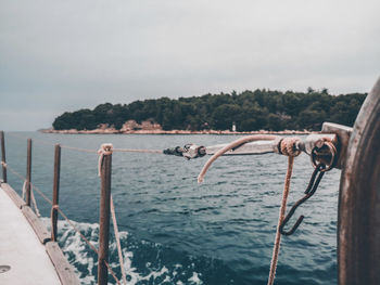 Wooden posts in sea against sky