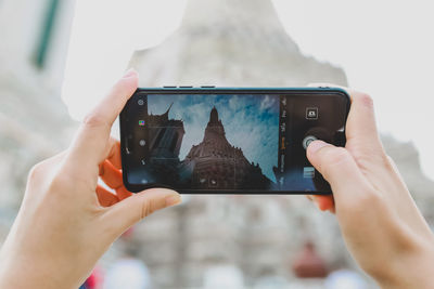 Midsection of man photographing with mobile phone