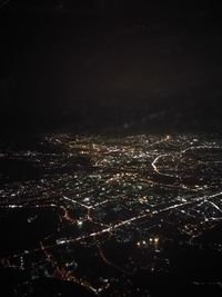 Aerial view of illuminated cityscape against sky at night