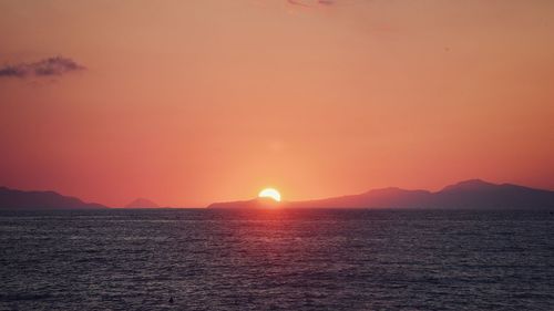 Scenic view of sea against romantic sky at sunset