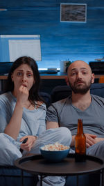 Portrait of young couple sitting on table