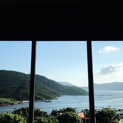 Scenic view of sea and mountains against sky