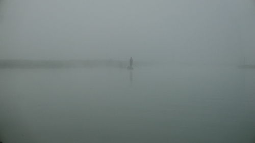 Scenic view of lake against sky during foggy weather