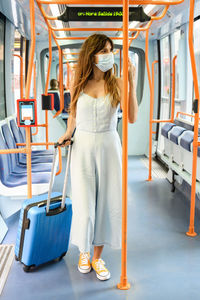 Woman wearing mask standing in bus