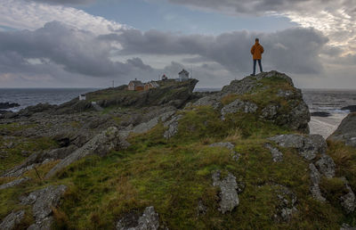 Rear view of man walking on mountain against sky