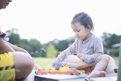 Side view of boy playing with toy blocks at home