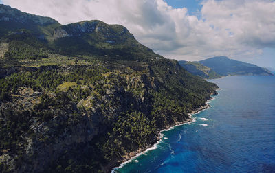 Scenic view of sea and mountains against sky