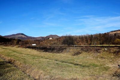 Scenic view of field against blue sky