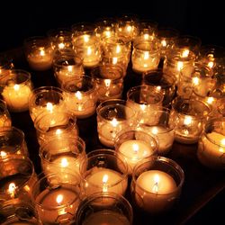 Close-up of lit candles in row