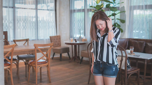 Woman standing on chair in restaurant