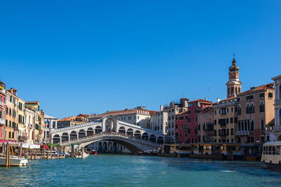 View of buildings in city against blue sky