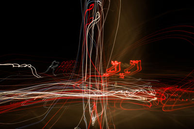 Illuminated light trails against black background