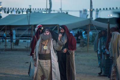 People wearing traditional clothing while standing outdoors