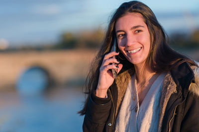 Young woman talking on phone outdoors