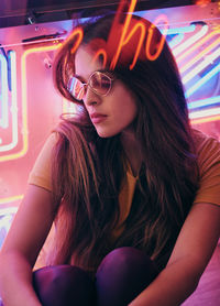 Portrait of beautiful young woman sitting in sunglasses