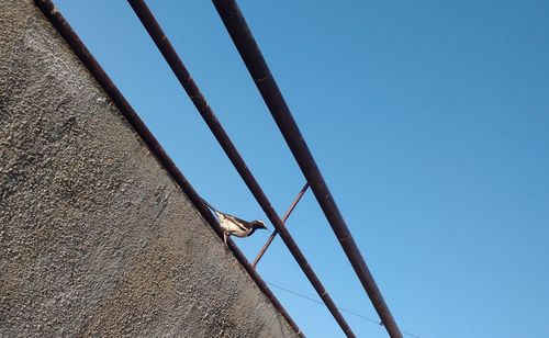 Low angle view of metallic structure against clear blue sky