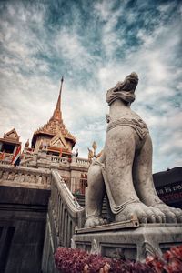 Statue of temple building against cloudy sky