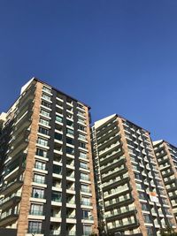 Low angle view of modern building against clear blue sky