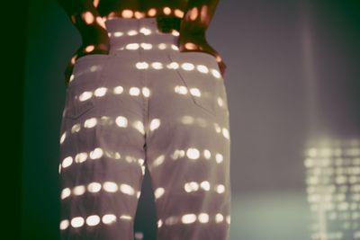 Close-up of woman standing against illuminated lights