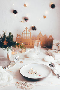  plate, cutlery, champagne glass and christmas decorations. tablescapes on white wooden table