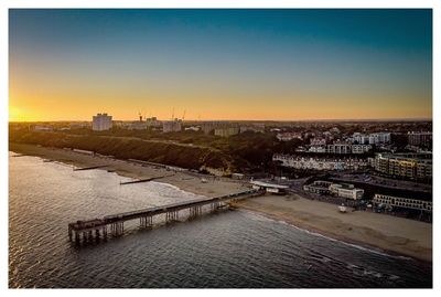 High angle view of river by buildings against sky during sunset