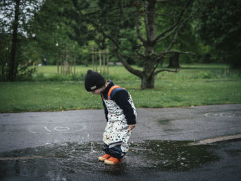 Side view of boy standing in rain