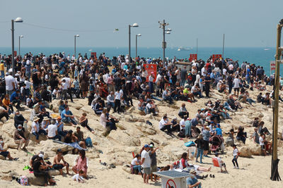 People at beach against clear sky