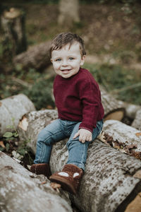 Portrait of cute boy sitting on rock