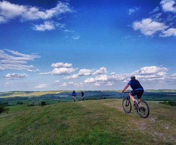 People on bicycle against sky