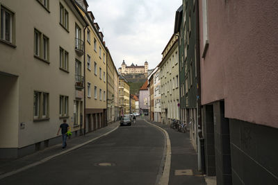 Street amidst buildings against sky in city