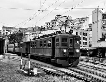 Train on railroad tracks in city against sky