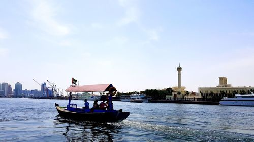 Boat in river with city in background