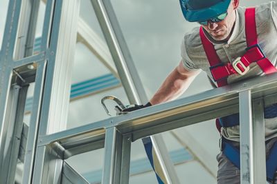 Low angle view of man working by railing at construction site