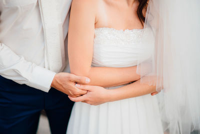 Midsection of couple holding hands
